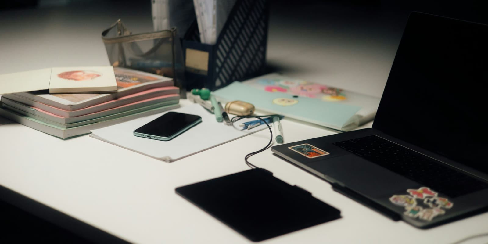 Mesa de trabajo con papeles, taza de café y luz tenue al final del día