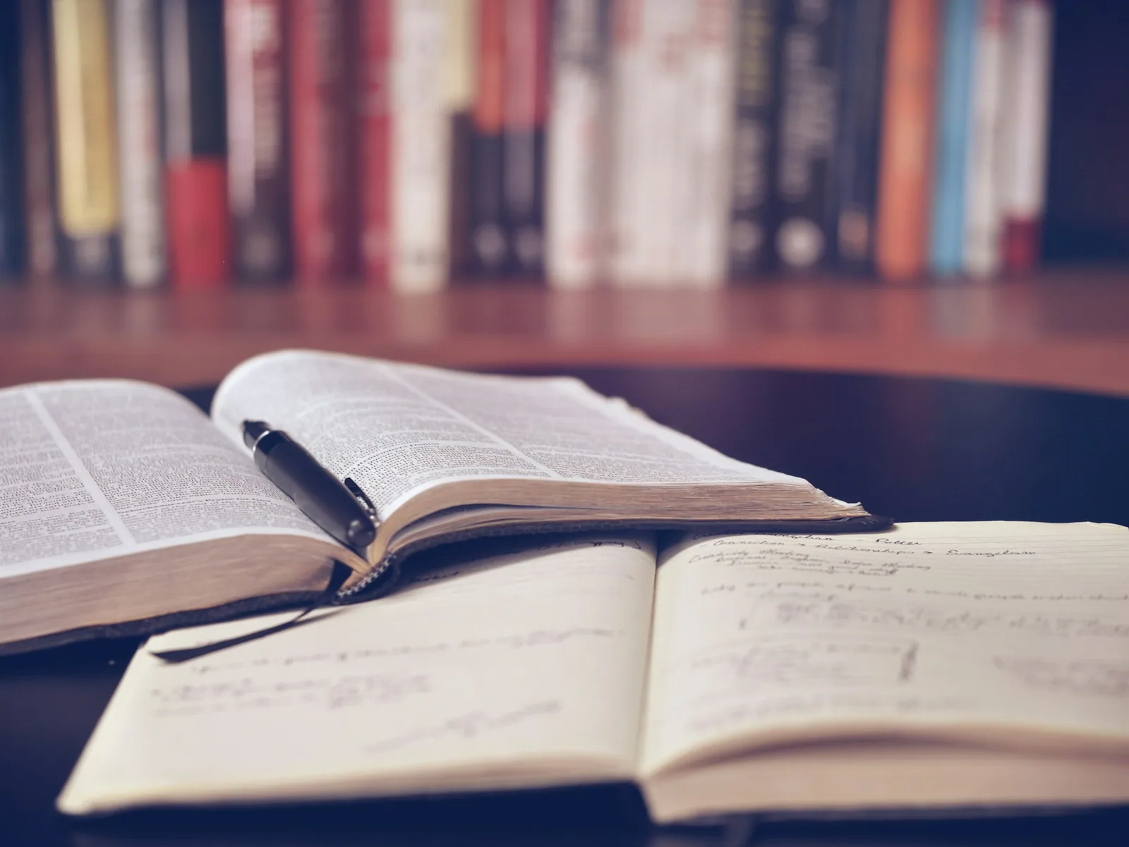 Pila de libros académicos sobre una mesa de madera